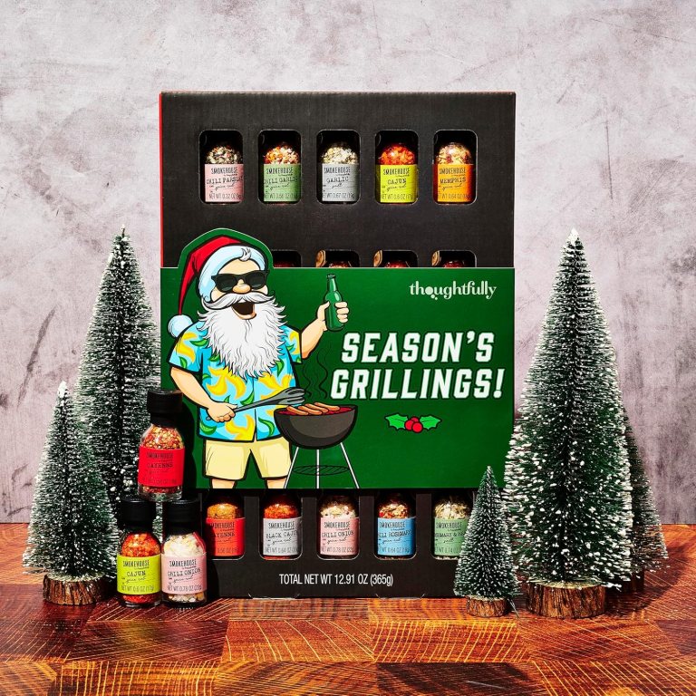 A gift set featuring various spice seasonings for grilling, presented in a festive box with a playful illustration of a Santa character barbecuing. The background includes small faux evergreen trees, enhancing the holiday theme.