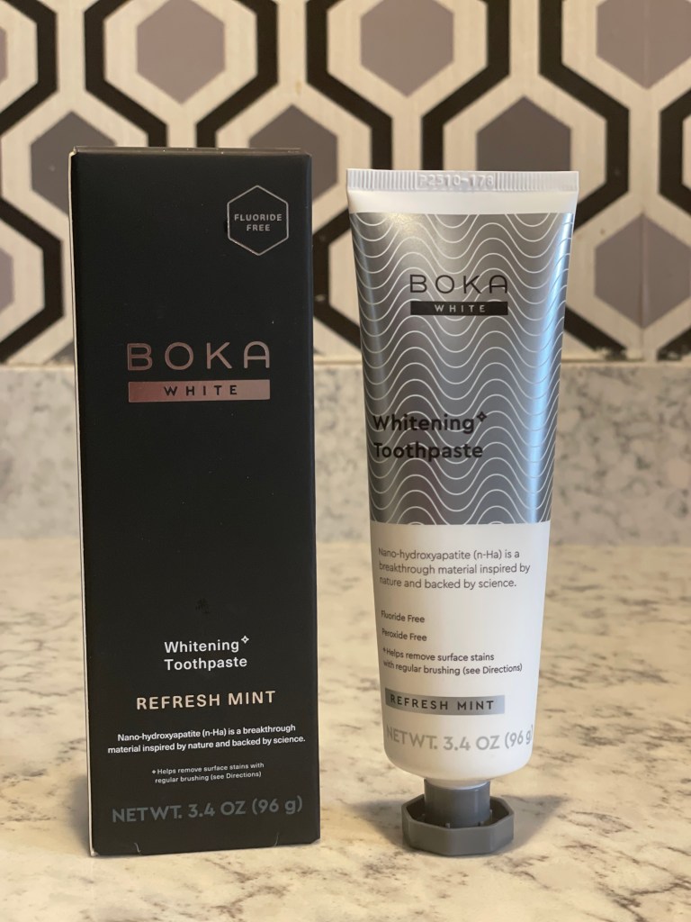 A box and tube of Boka White Whitening Toothpaste in Refresh Mint flavor, featuring information about being fluoride-free and containing nano-hydroxyapatite as a key ingredient.