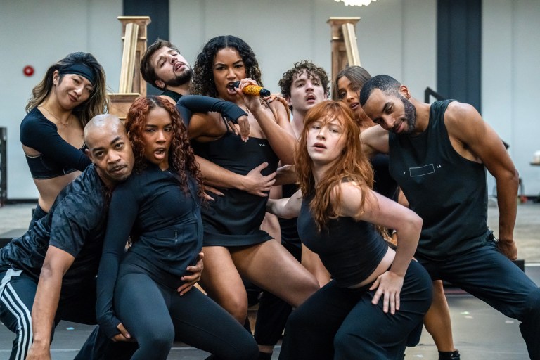 A diverse group of dancers performing a choreographed routine in a rehearsal space, showcasing dynamic poses and expressions.