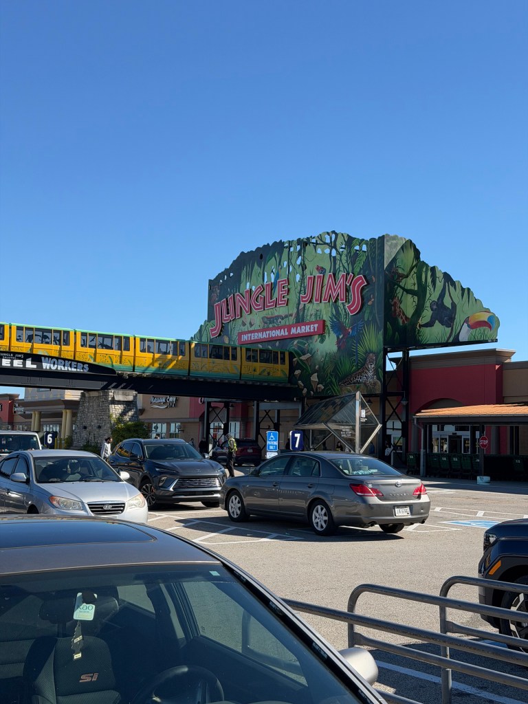 Exterior view of Jungle Jim's International Market featuring vibrant signage and a parking lot filled with cars.